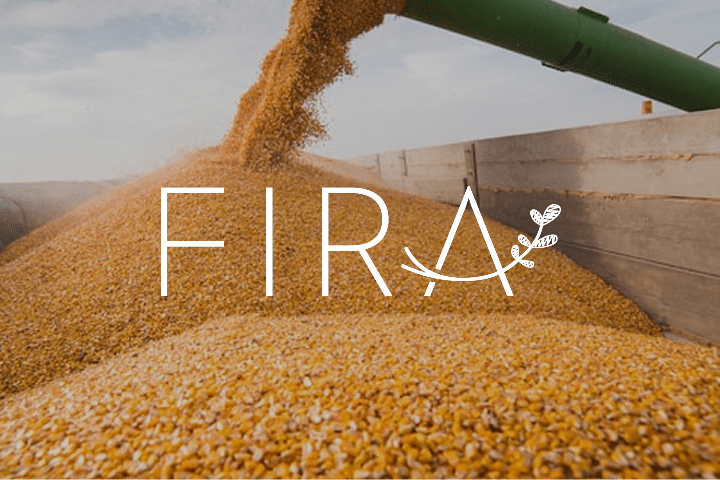 A large pile of yellow corn kernels being poured from a green chute into a truck bed, with the word FIRA and a leaf graphic overlayed on the image, capturing the energy of major agricultural events.