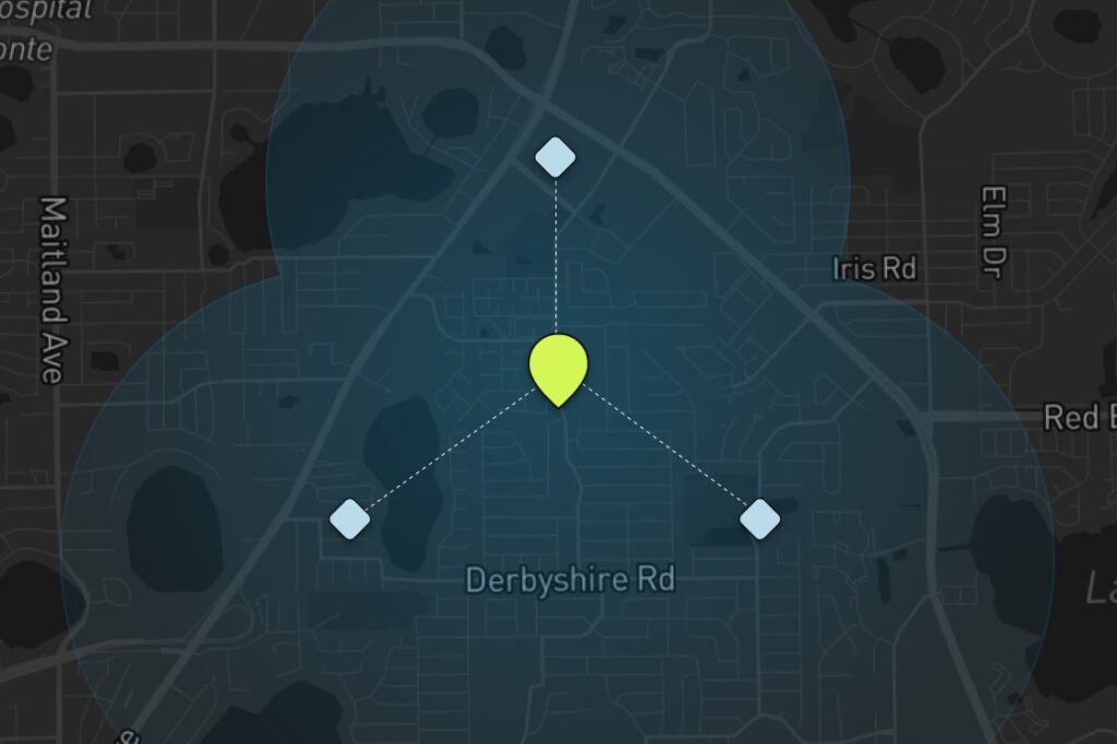 A map with a central yellow marker connected by dashed lines to three blue diamond markers, forming a triangle over Derbyshire Rd, with shaded blue circles overlapping around each marker. Streets and landmarks are faintly visible.