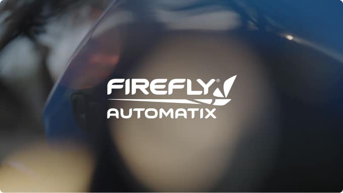 White FIREFLY AUTOMATIX logo with a stylized leaf, centered on a blurred background featuring dark and light circular shapes.