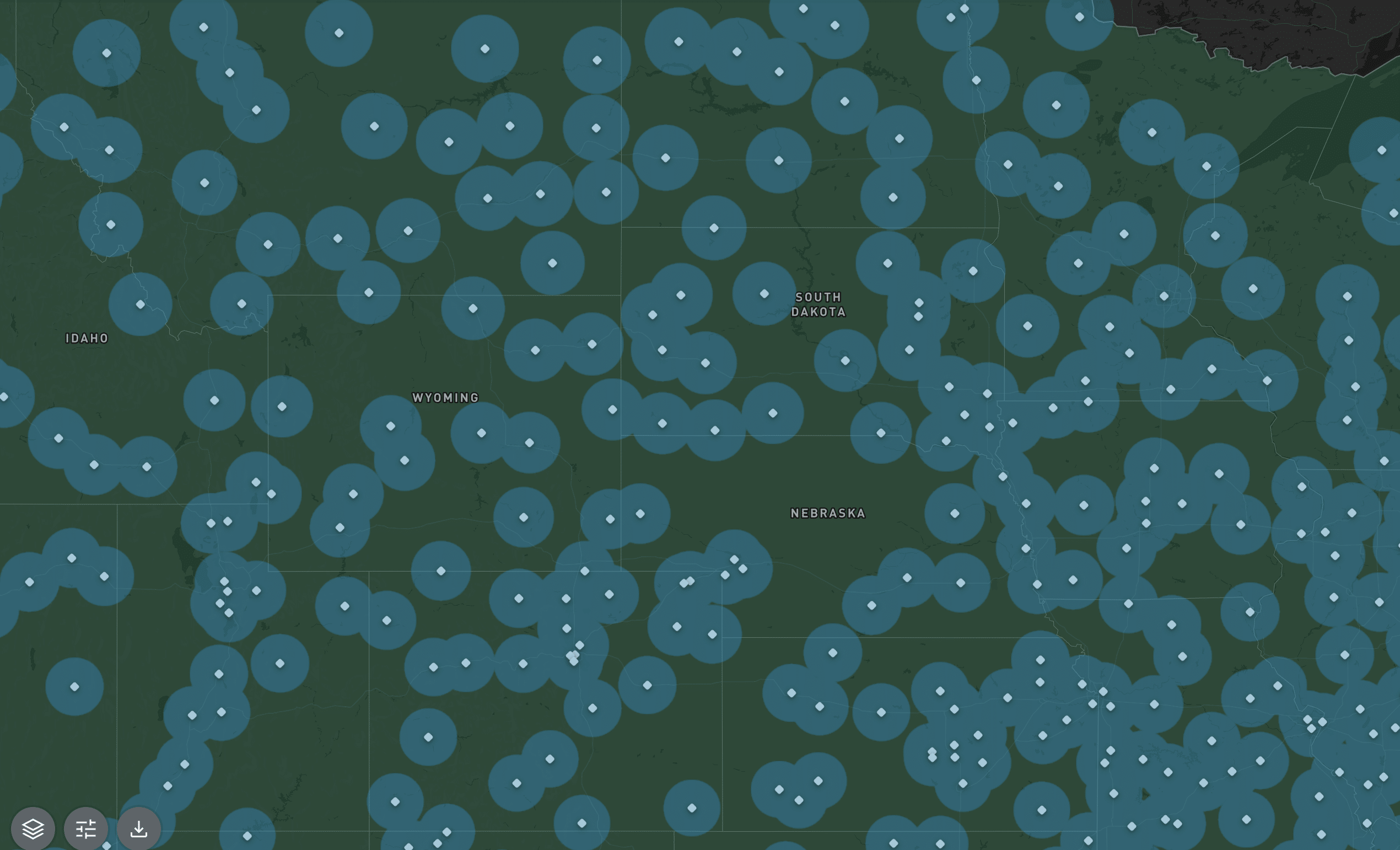 A map of RTK base stations showing Idaho, Wyoming, South Dakota, and Nebraska, overlaid with numerous blue circles indicating density of base stations within 40 km evenly distributed across the regions.
