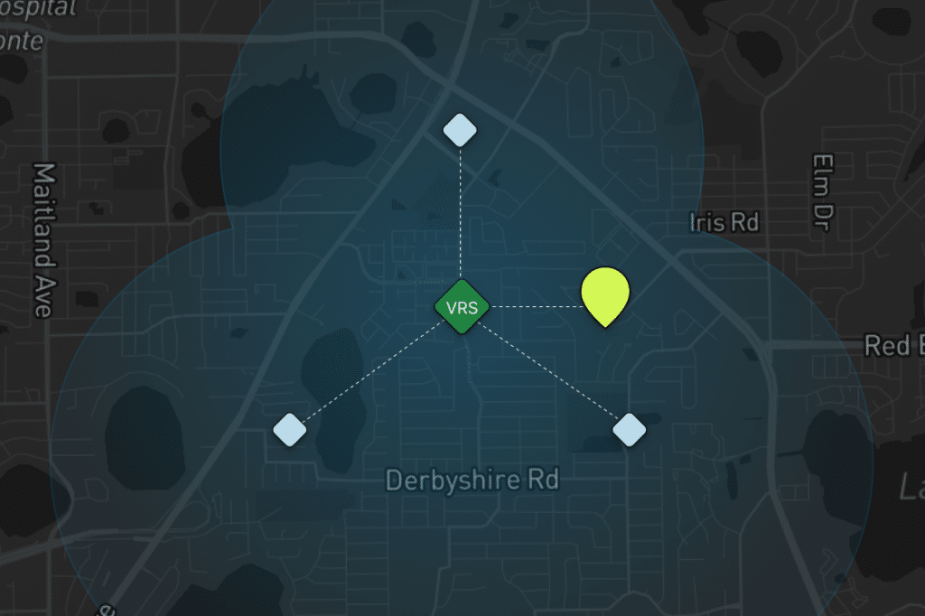 A dark map showing Derbyshire Rd and nearby streets, with blue shaded areas, three blue diamond-shaped nodes linked to a green VRS hexagon at the center, and a yellow-green marker to the right of the center.