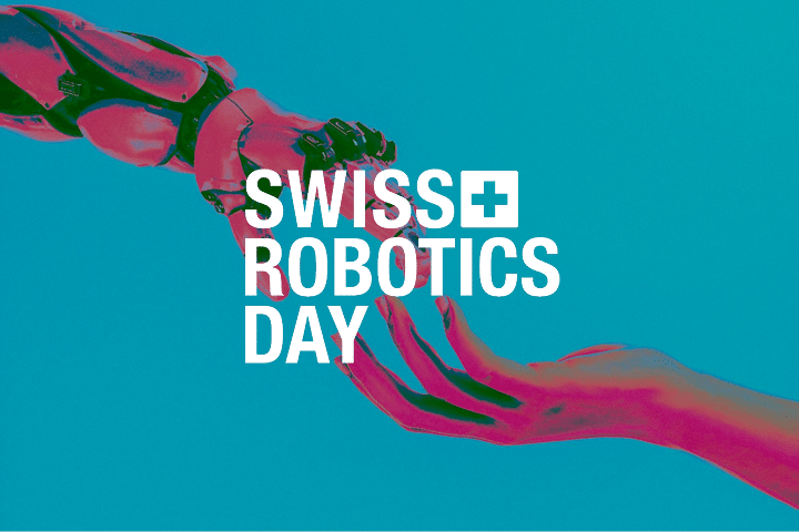 A robotic hand and a human hand reaching toward each other on a blue background, highlighting the innovative spirit of Swiss robotics, with the text Swiss Robotics Day in bold white letters across the center.